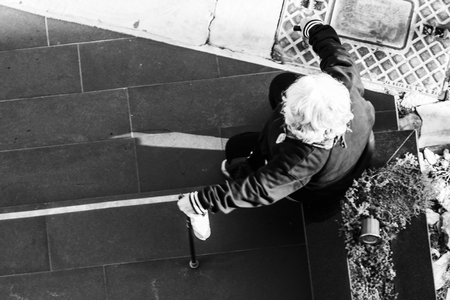 Old woman sitting alone at the streetの写真素材