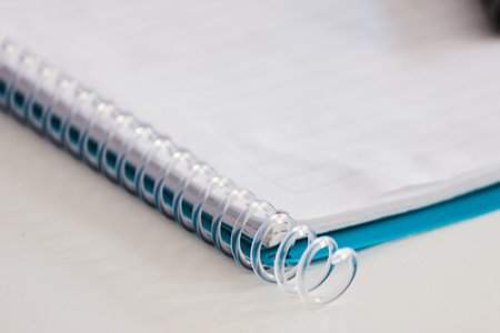 Notebook opened on a white deskの写真素材