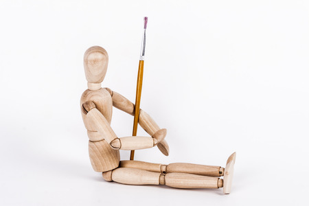 Wooden puppet holding painting brushの写真素材