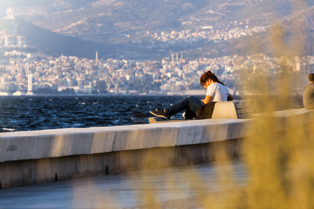 Girl sitting on a bench at seaside in Izmir (Turkey)のeditorial素材