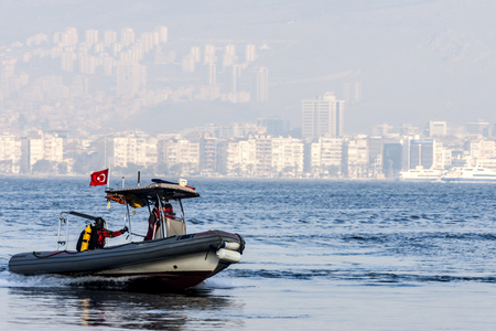 Policemen divers on a rubber dinghy going fast on the seawater in front of Izmir (Turkey) - photographyの写真素材