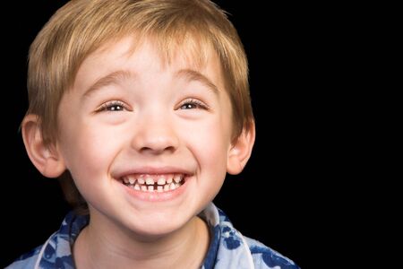 Friendly boy with a blue shirt against a black background