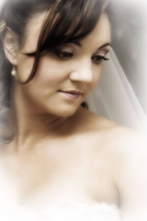 Beautiful brunette bride wearing pearl earrings and a veilの写真素材
