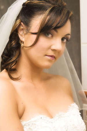Beautiful brunette bride wearing pearl earrings and a veilの写真素材