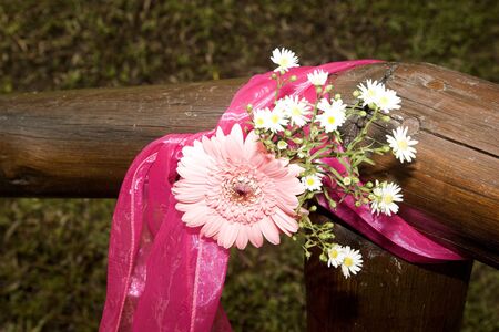Decorative flowers tied to wooden guard rail at weddingの写真素材