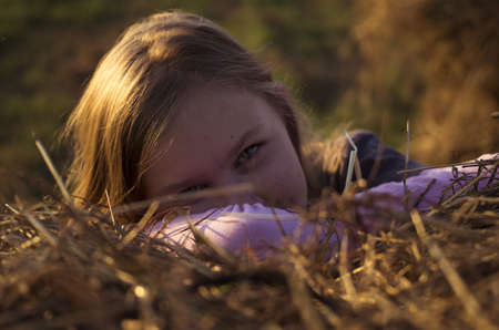 Portrait of teenage girl in the field with corn ears and strawの写真素材