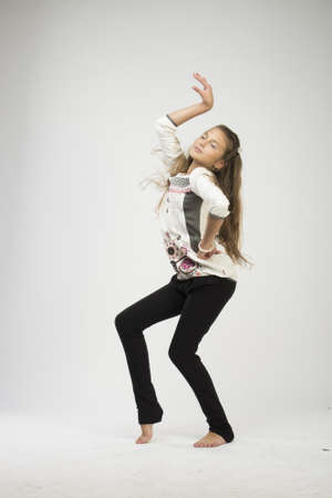 Cute teenage girl smiling and dancing in studioの写真素材