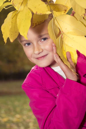 Little preteen girl playing outdoor in park at autumnの写真素材