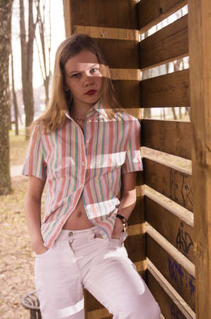 young teenage girl looking staring near wooden denceの写真素材
