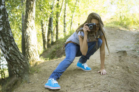 teenage girl  shoting with vintage film camera in the parkの写真素材