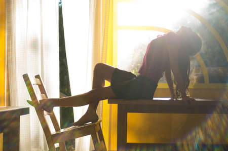 young girl sitting on the table in summer inside pavilionの写真素材