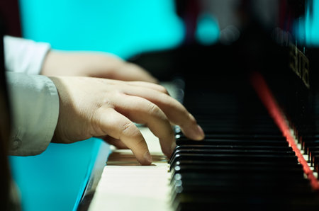 Close-up of a childs hands playing piano with precisionの写真素材