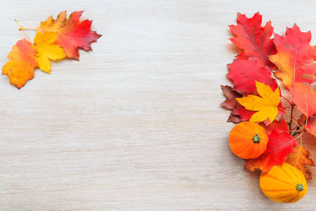 Autumn decor from pumpkins and leaves on a wooden background. Flat lay autumn composition with copy space.の写真素材