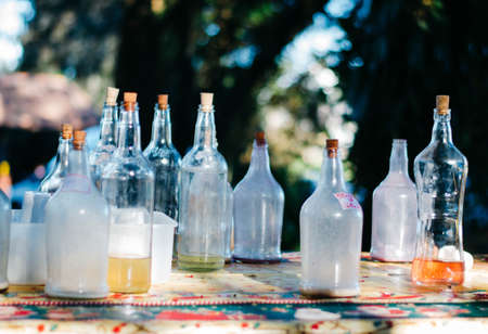Empty liquor bottles in a christmas tablecloth in the outdoors during an event.の写真素材