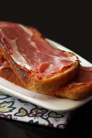 Plate of serrano ham with tomato, olive oil and bread  の写真素材