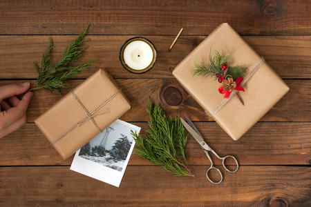 Hand crafted gifts on rustic wooden background with Christmas decorationの写真素材