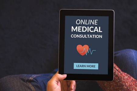 Hands holding digital tablet computer with online medical consultation concept on screen. All screen content is designed by me. View from above.の写真素材