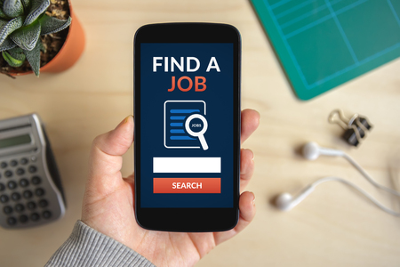 Hand holding smart phone with find a job concept on screen. All screen content is designed by me. Flat layの写真素材