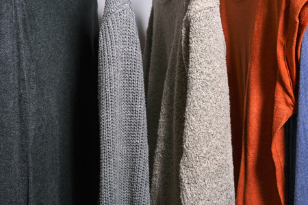 Close up shot of clothing hanging on a clothing rack in a shop or home closet.の写真素材