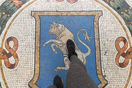 The good luck ritual of spinning on the balls of the bull in the Galleria Vittorio Emanuele II in Milan, Italyの写真素材