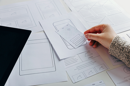 Web designer creating mobile responsive website. Website wireframe sketches on white tableの写真素材