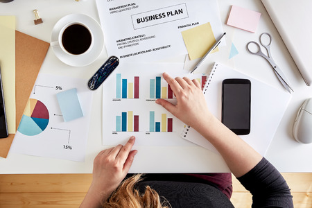 Overhead view of young woman entrepreneur planning business strategy. Desk of a modern businesswomanの写真素材