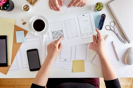 UX graphic designers planning out the structure of a mobile application. Wireframing stage of a web...