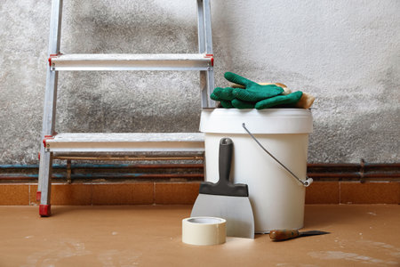 Plastering instruments tools and materials for room renovation against weathered wall.の写真素材