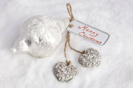 Merry christmas on card with hearts in snowの写真素材