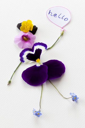 Greeting card with a doll made of flowers, paper balloon and the text helloの写真素材