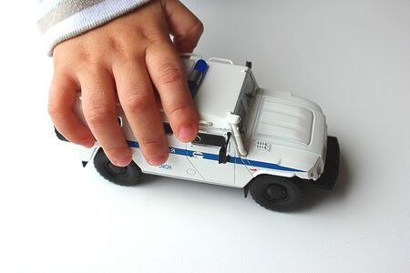 a child holds a toy car in his handの写真素材