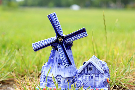 Porcelain windmill with barn and flowers on the grassの写真素材