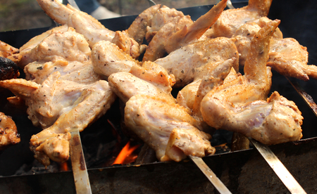 Skewers of chicken wings roasting on the grillの写真素材