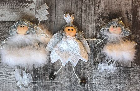 three Christmas angel in fluffy white dresses holding handsの写真素材