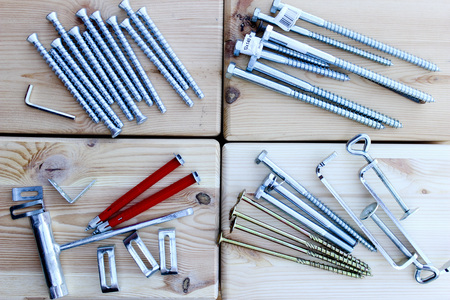 Anchors, screws and bolts of different lengths and shapes on the wooden boxesの写真素材