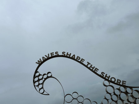 wrought iron fence against the background of the cloudy sky with an inscription