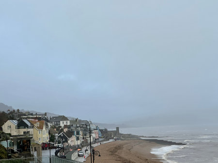 A view of the beach and houses on a foggy day Lyme Regis Dorset Englandの写真素材