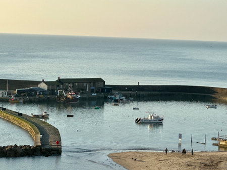 Fishing boats moored at the entrance to the harbour at sunrise Lyme Regis Dorset Englandの写真素材