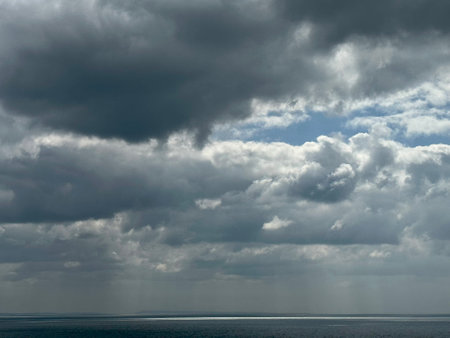 Stormy sky with dark clouds and sea surface. Natural background.の写真素材