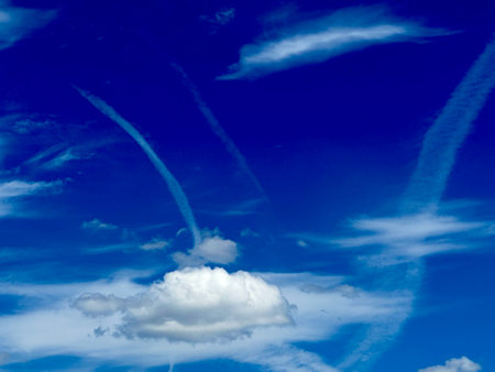 blue sky background with white clouds and contrail, closeup of photo