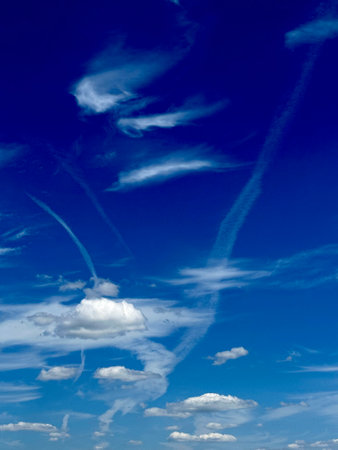 blue sky background with white clouds and contrail, closeup of photo