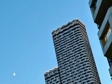 Skyscraper and the moon in the blue sky