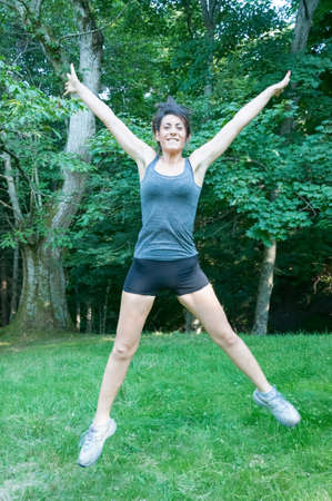happy beautiful girl jump on park of camaldoliの写真素材