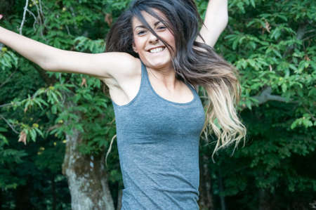 happy beautiful girl jump on park of camaldoliの写真素材