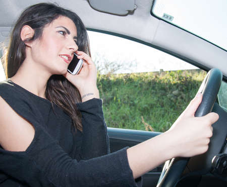 female driver with his smart phone in a sunny day