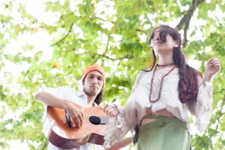 hippies dance and play guitar in a sunny dayの写真素材