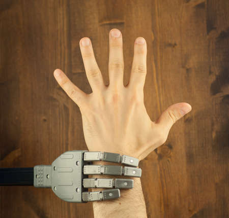 robot and human hand in a battle for workの写真素材
