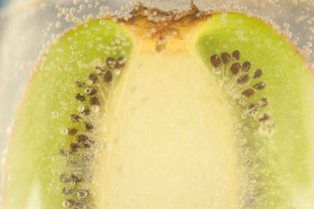 beautiful detail of kiwi in a glass of a sparkling waterの写真素材