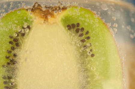 beautiful detail of kiwi in a glass of a sparkling waterの写真素材