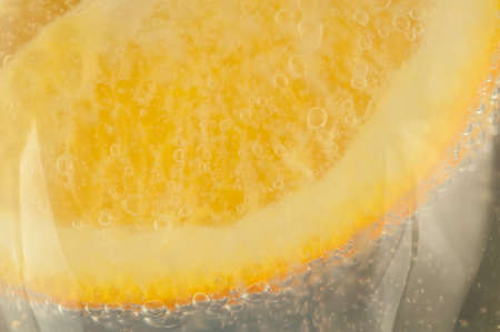 beautiful detail of orange and bubble in a glass of a sparkling waterの写真素材